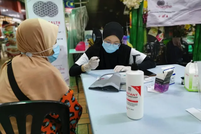 A one-on-one consultation at the Remedine community screening table