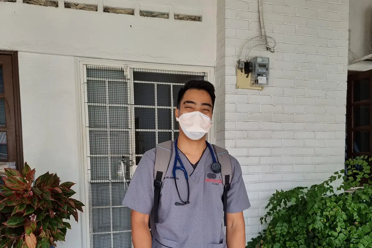 Dr Wan Afdzal arriving at a patient's front door for a home visit