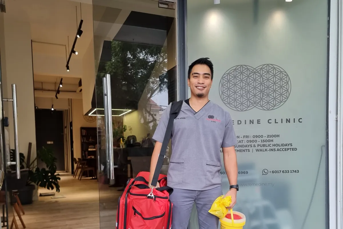 Dr Wan Afdzal leaving the clinic with his housecall medical bag