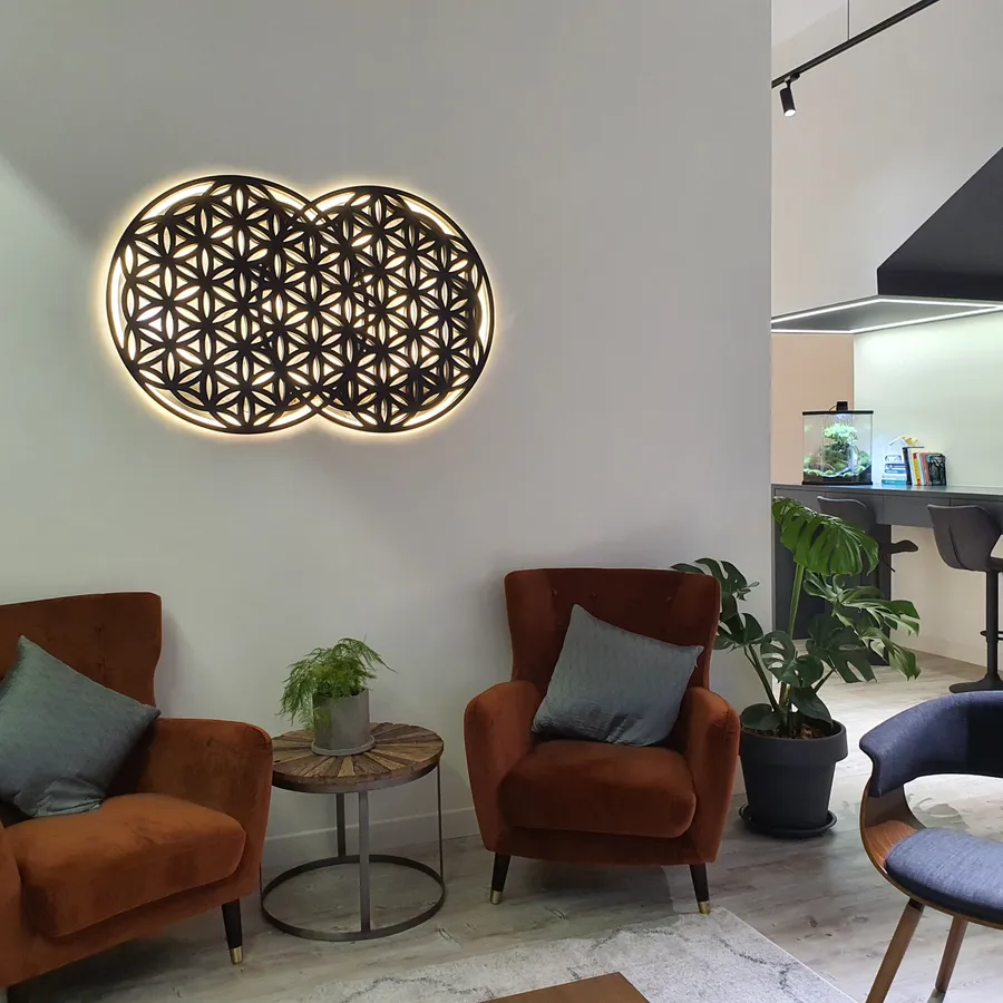 The waiting lounge at Remedine Clinic, with terracotta armchairs beneath the illuminated flower-of-life panel