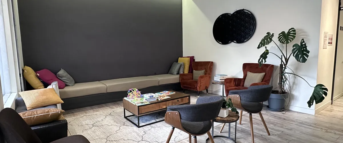 The waiting lounge at Remedine Clinic, with terracotta armchairs and warm lighting