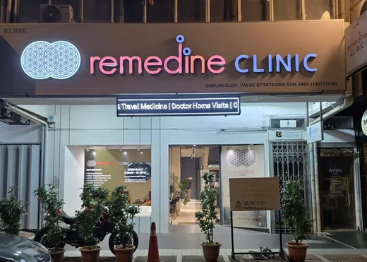 The Remedine Clinic storefront lit up at night, open until 8:30pm